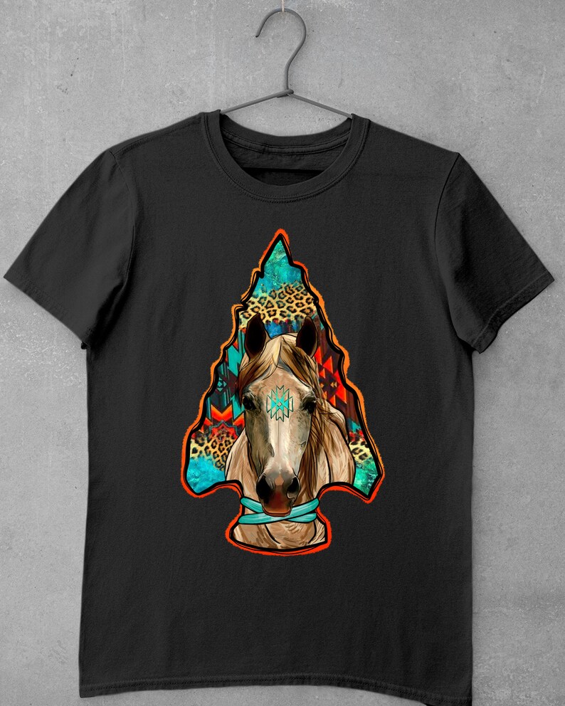 May include: Black t-shirt featuring a colourful graphic of a horse's head within an arrowhead. The arrowhead is filled with geometric patterns and animal print.