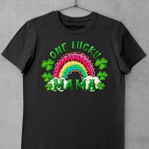 May include: Black t-shirt with a rainbow and shamrock design. The rainbow is pink, red, orange, yellow, green, blue, and purple. The text "One Lucky Mama" is written in white.