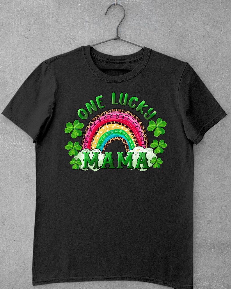 May include: Black t-shirt with a rainbow and shamrock design. The rainbow is pink, red, orange, yellow, green, blue, and purple. The text "One Lucky Mama" is written in white.