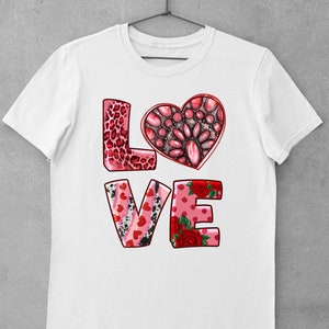 May include: White t-shirt with a pink, red, and black "LOVE" graphic. The letters are decorated with hearts, leopard print, and floral patterns.