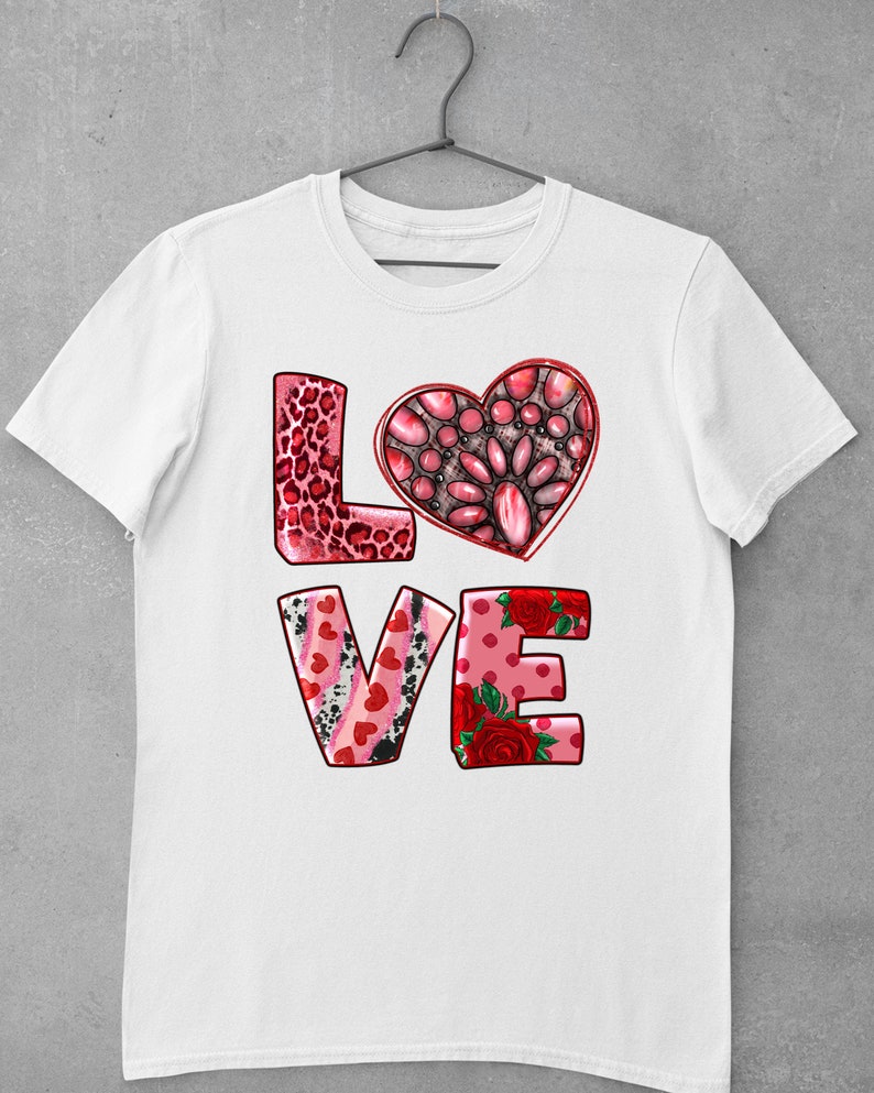 May include: White t-shirt with a pink, red, and black "LOVE" graphic. The letters are decorated with hearts, leopard print, and floral patterns.