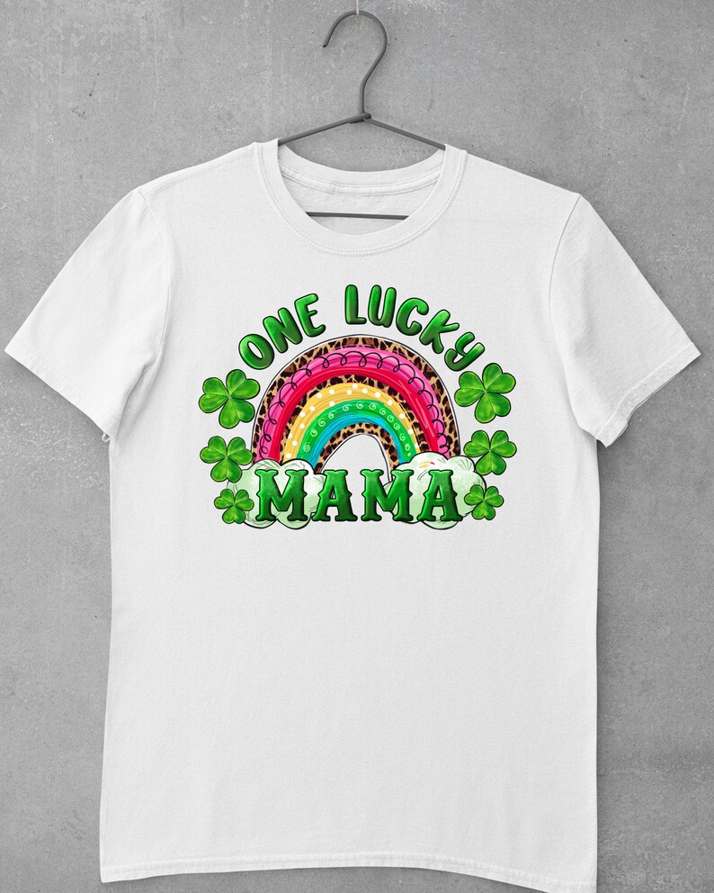 May include: White t-shirt with a rainbow design and the text "One Lucky Mama" in green and black lettering. The rainbow is decorated with leopard print and green shamrocks.