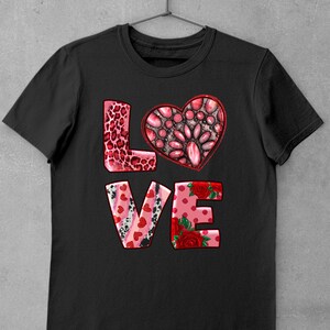May include: Black t-shirt with a pink, red, and white "LOVE" graphic. The "O" is a heart shape with a pink, red, and white patterned design.