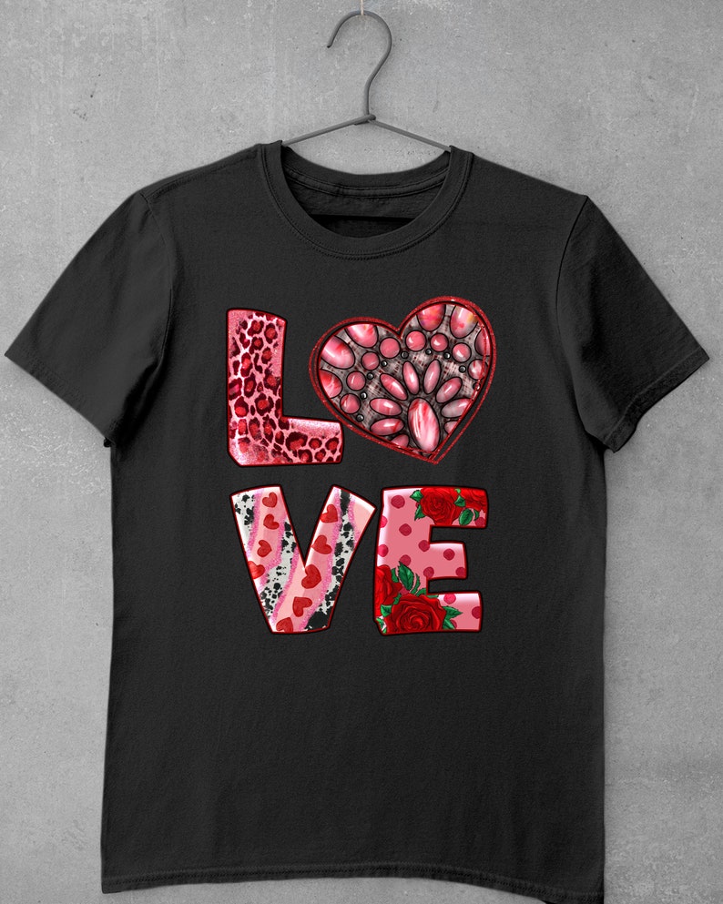 May include: Black t-shirt with a pink, red, and white "LOVE" graphic. The "O" is a heart shape with a pink, red, and white patterned design.
