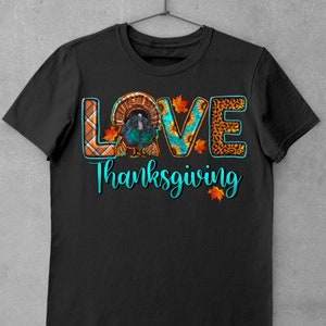 May include: Black t-shirt with a turquoise graphic that says "LOVE" with a turkey in the "O". The graphic also includes plaid, sunflower, and leopard print patterns. The text "Thanksgiving" is below the graphic.