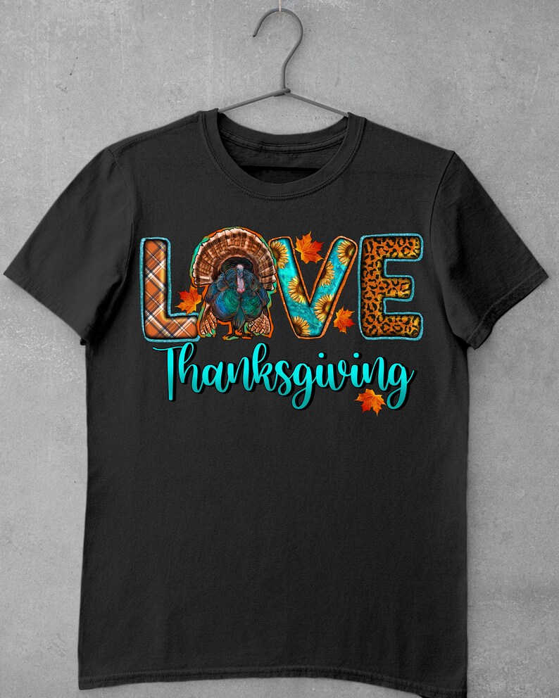 May include: Black t-shirt with a turquoise graphic that says "LOVE" with a turkey in the "O". The graphic also includes plaid, sunflower, and leopard print patterns. The text "Thanksgiving" is below the graphic.