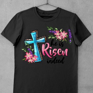 May include: Black t-shirt with a blue cross, pink flowers, and the text "He is Risen indeed".