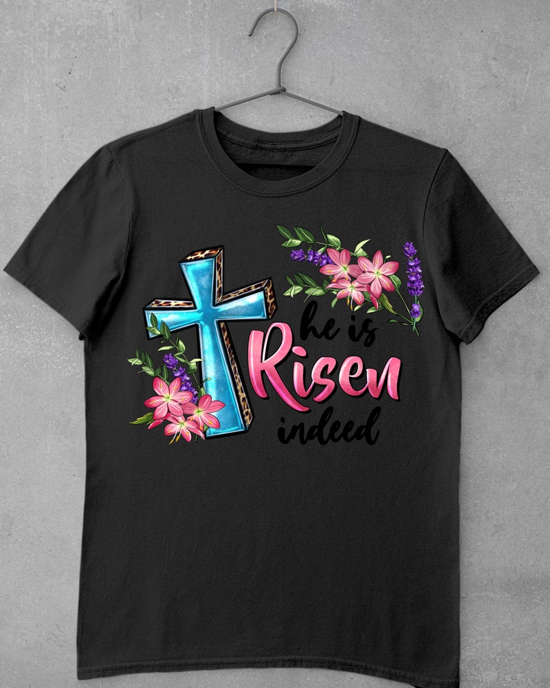 May include: Black t-shirt with a blue cross, pink flowers, and the text "He is Risen indeed".