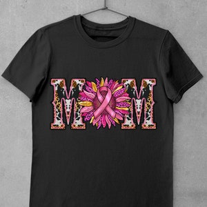 May include: Black t-shirt with a pink ribbon and sunflower design. The word "MOM" is spelled out in large letters with a leopard print background.