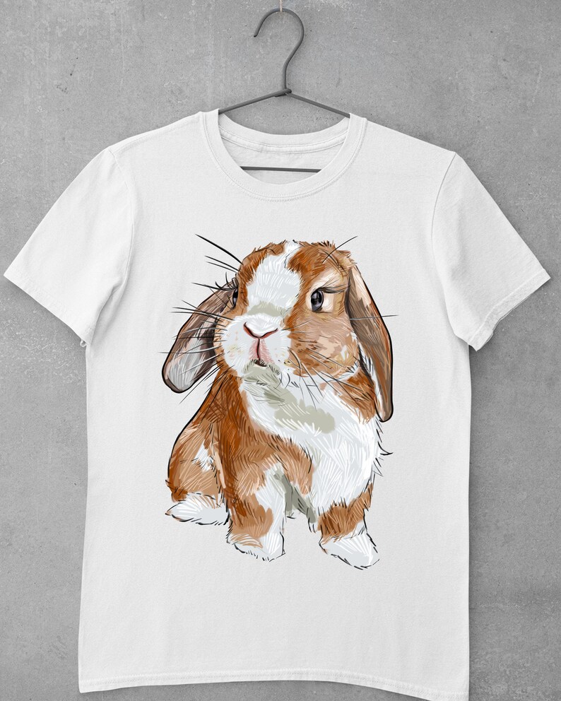 May include: A white t-shirt with a brown and white rabbit illustration. The rabbit has long ears and is looking at the viewer.