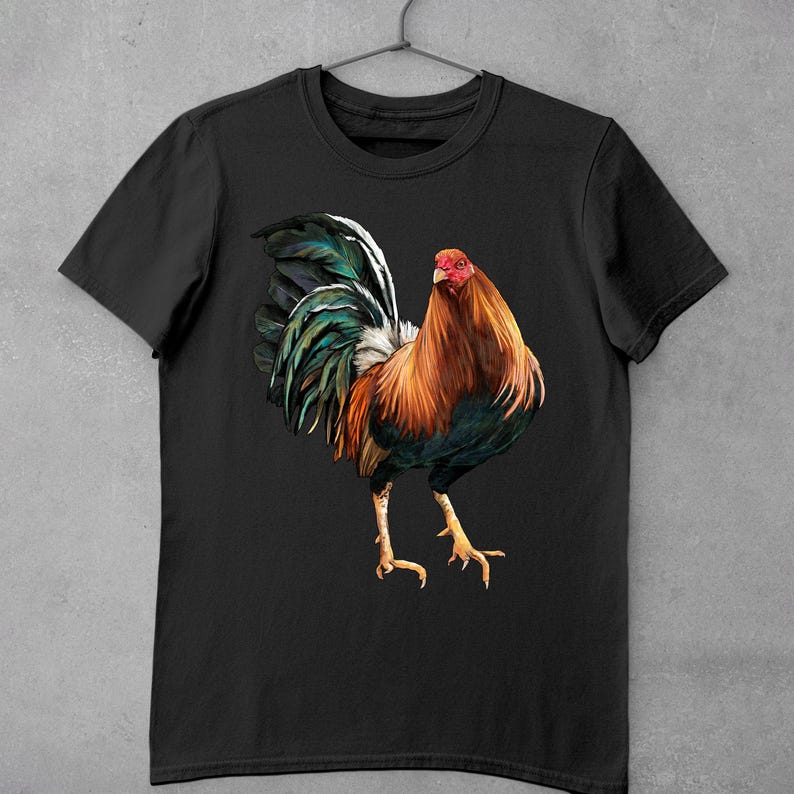 May include: Black t-shirt with a colorful rooster illustration. The rooster has a red comb and wattle, a green and blue tail, and a brown and black body.