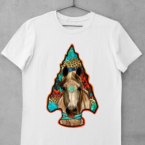 May include: White t-shirt featuring a colourful graphic of a horse's head within an arrowhead design. The arrowhead is filled with geometric patterns and animal print.