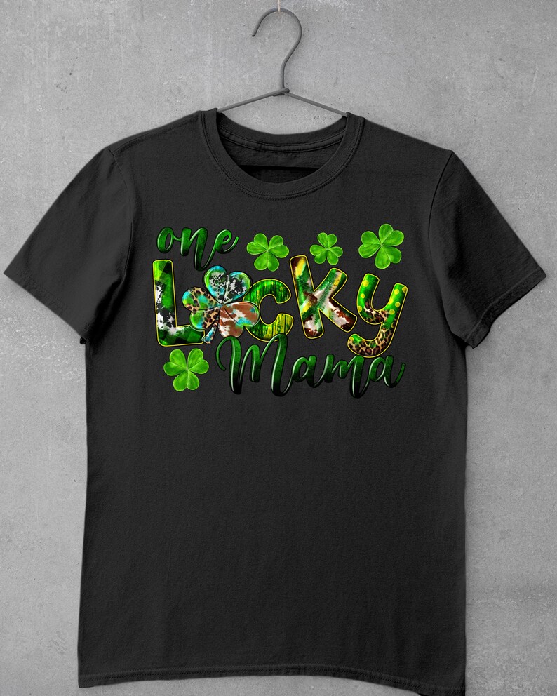 May include: Black t-shirt with the text "one lucky mama" in green and white letters with shamrock designs.