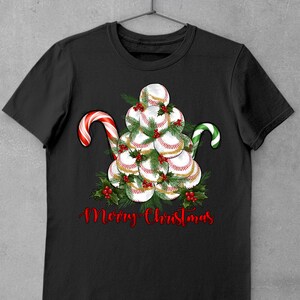 May include: Black t-shirt with a Christmas tree made of baseballs and candy canes. The text "Merry Christmas" is written below the tree.