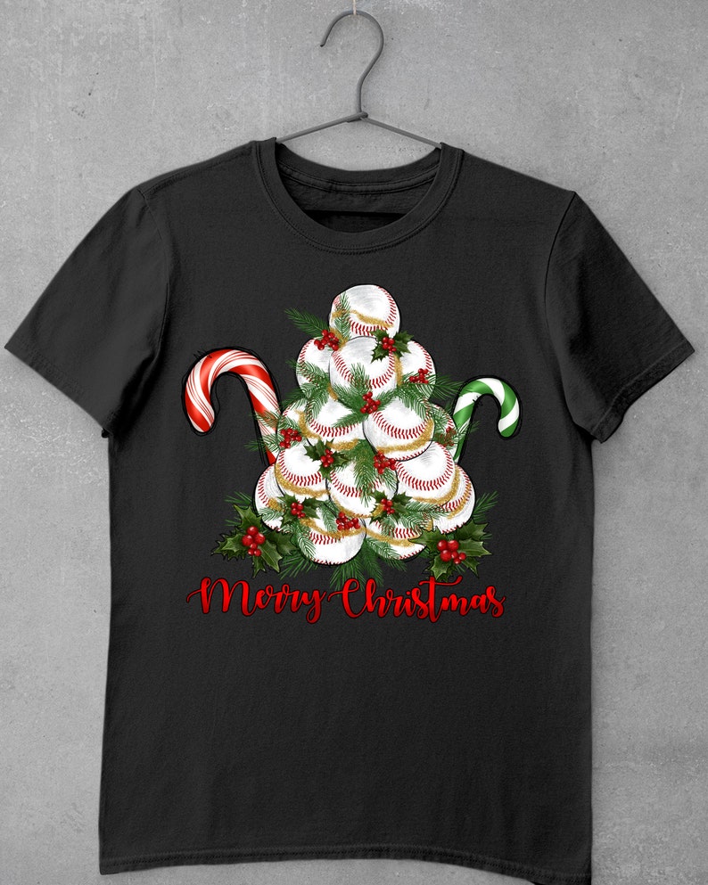 May include: Black t-shirt with a Christmas tree made of baseballs and candy canes. The text "Merry Christmas" is written below the tree.