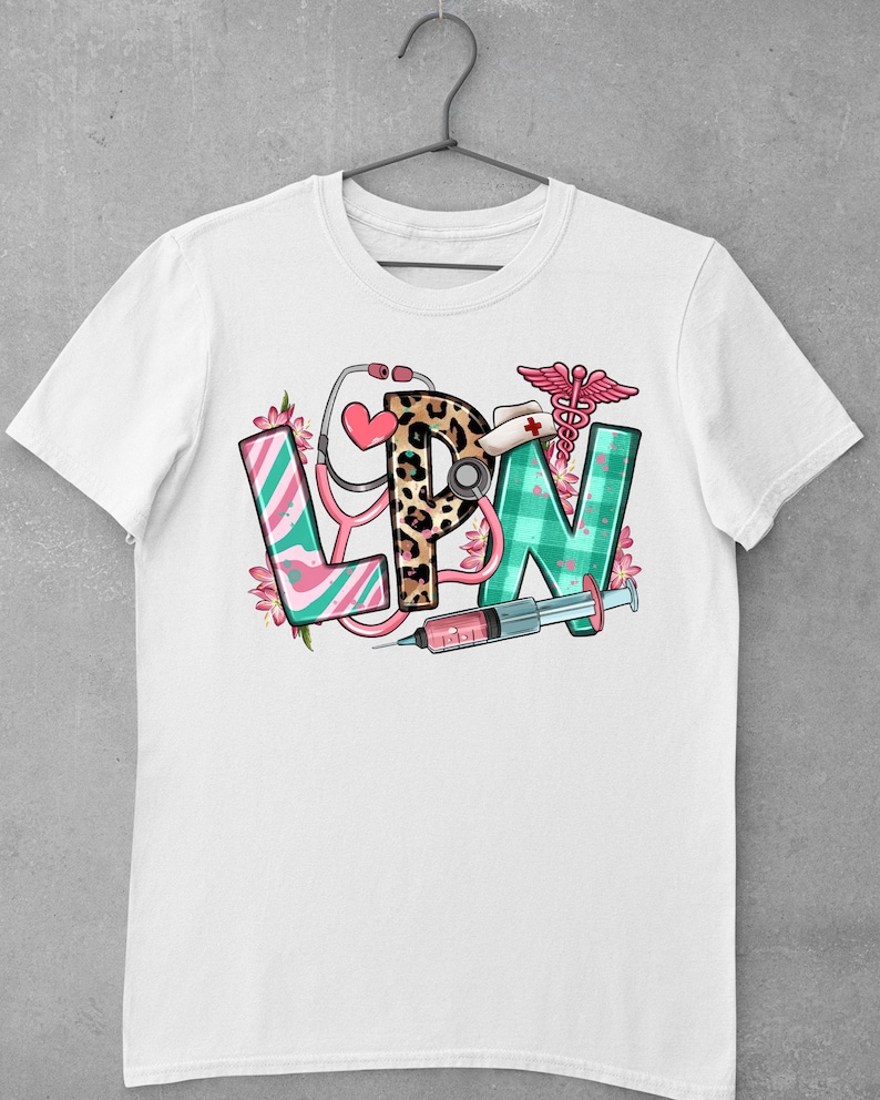 May include: White t-shirt with a graphic design of the letters LPN in colorful patterns, surrounded by medical symbols like a stethoscope, a syringe, and a caduceus.
