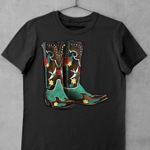 K&ouml;nnte beinhalten: Schwarzes T-Shirt mit einem Motiv von zwei braunen Cowboystiefeln mit gr&uuml;nen und roten Blumendesigns.