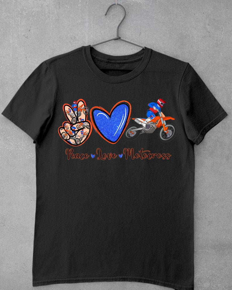 May include: Black t-shirt with a peace sign, heart, and motocross rider graphic. The peace sign is made up of smaller motocross riders. The text "Peace Love Motocross" is below the graphic.