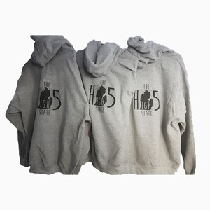 May include: Three gray hooded sweatshirts with a black graphic on the back. The graphic is a silhouette of the state of Michigan with the text "The High 5 State" underneath.