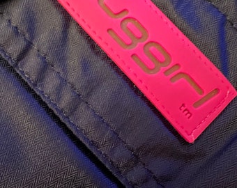 May include: A pink label with the word "bugirl" in white lettering and a trademark symbol.