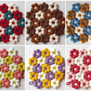 May include: Six crocheted flower pot holders in various colours, including red, blue, brown, yellow, purple, and pink. Each pot holder is made of yarn and features a circular design with multiple flower shapes.
