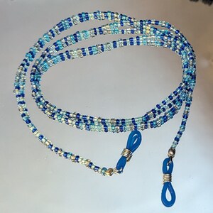 May include: A blue, white and silver beaded eyeglass chain with blue rubber end pieces.