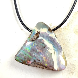 May include: A triangular opal pendant with a black leather cord. The opal features a mix of colors, including white, purple, green, and brown. The pendant is approximately 2 inches wide and 2 inches tall.