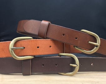 May include: Three leather belts with brass buckles. The belts are brown, tan, and dark brown. The buckles are all the same style.