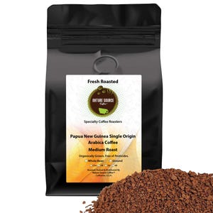 May include: A black bag of Papua New Guinea single origin Arabica coffee, medium roast. The bag is labeled "Fresh Roasted" and "Nature Source Coffee". The label also states that the coffee is organically grown, free of pesticides, and roasted, packed, and distributed by Nature Source Coffee in California, USA.
