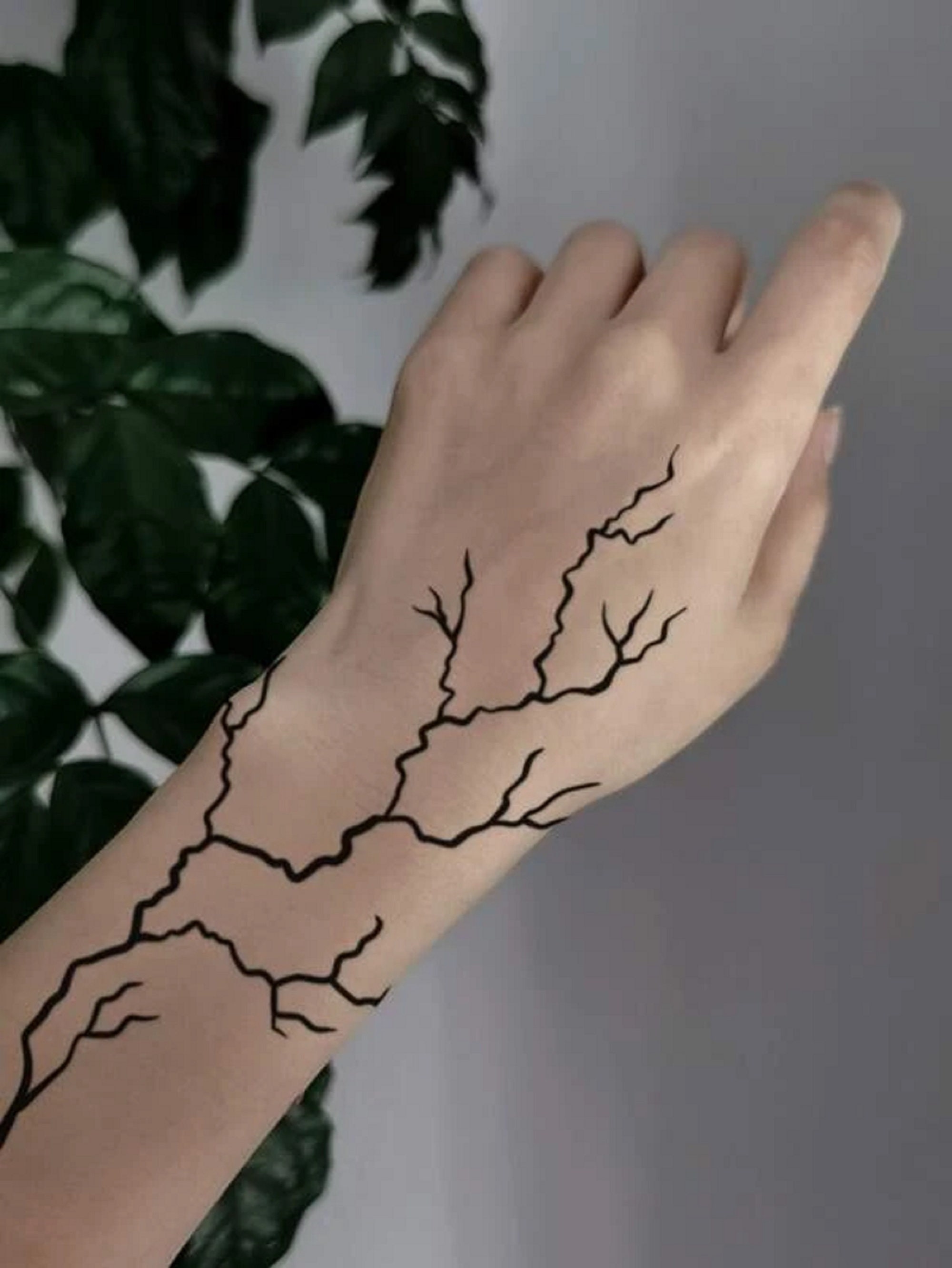 Minimalist lightning bolt tattoo on the wrist