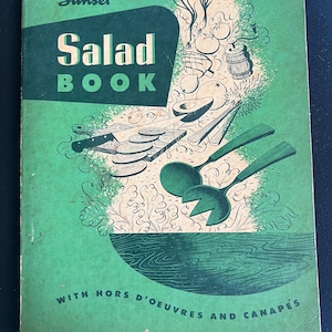 May include: A vintage green cookbook titled "Sunset Salad Book" with illustrations of vegetables, a salad bowl, and utensils. The book also includes the text "With Hors d'oeuvres and Canapés".