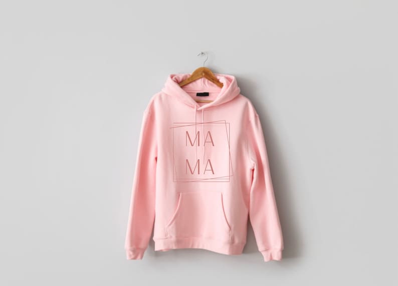 May include: A pink hoodie with a pocket and a graphic that says "MA MA" in a box.