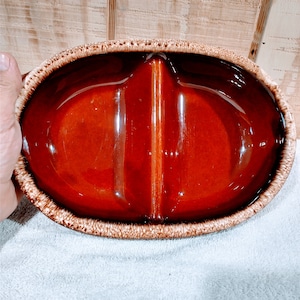 May include: A divided serving dish with a brown glaze and a white rim. The dish is oval shaped and has two sections.