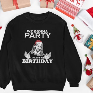 May include: Black sweatshirt with a white graphic of a man wearing a Santa hat and a beard. The text on the graphic reads "We gonna party like it's my birthday".