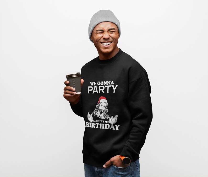 May include: A black sweatshirt with a white graphic of Jesus wearing a Santa hat and the text "We gonna party like it's my birthday".