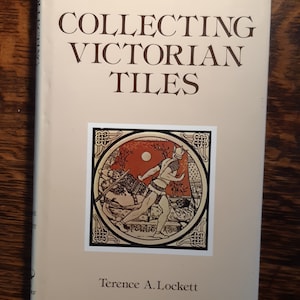 以下が含まれることがあります： テレンス・A・ロケット著「Collecting Victorian Tiles」というタイトルの本。表紙には、中世の風景の中に2人の人物が描かれたタイルのカラフルなイラストが掲載されています。