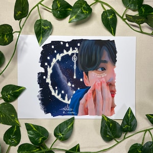 Puede incluir: Una ilustración digital de una persona con cabello oscuro y ojos azules. La persona está mirando al espectador y tiene la mano en la cara. El fondo es azul oscuro con estrellas blancas y una esfera de reloj.