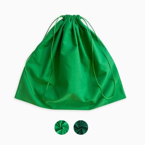 Könnte beinhalten: Eine grüne Stofftasche mit Kordelzug. Die Tasche ist oben zusammengezogen und hat einen Kordelzugverschluss.