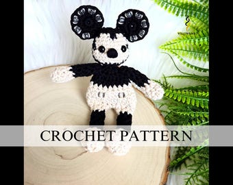 May include: A handmade crochet Mickey Mouse doll in black, cream, and white. The doll has large black ears with silver accents, a black nose, and a cream-colored body. The text "CROCHET PATTERN" is displayed at the bottom of the image.