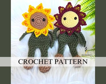 May include: Two crocheted sunflower dolls with green bodies and brown faces. One sunflower has yellow petals and the other has burgundy petals. The dolls are sitting on a white fluffy surface. CROCHET PATTERN is written in white text on a gray background.
