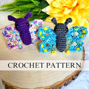 May include: Two handmade crochet butterflies in purple and blue, with colorful wings. The butterflies are displayed on a wooden surface, with the words "CROCHET PATTERN" below. A yellow flower and green leaves are in the background.
