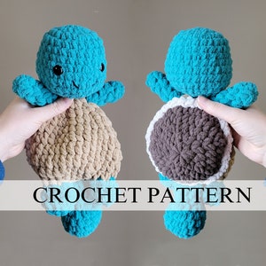 Puede incluir: Patrón de crochet para un juguete amigurumi de tortuga azul y marrón. El juguete está siendo sostenido por una mano. El patrón está disponible para su compra.
