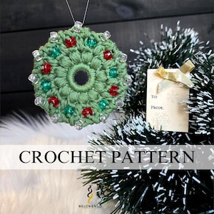 May include: A handmade green crochet ornament with red and green beads, and a central black mirror. The ornament is hanging on a Christmas tree with a gift tag. The text "CROCHET PATTERN" is displayed.