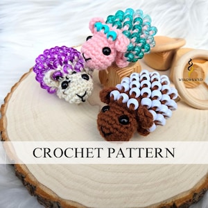 May include: Three crocheted sheep with beaded wool. The sheep are pink, brown, and white with purple, white, and turquoise beads, respectively. The sheep are sitting on a wooden slice with the text "CROCHET PATTERN" below them.