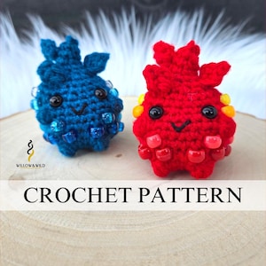 Könnte beinhalten: Zwei gehäkelte Kreaturen, eine blaue und eine rote, mit schwarzen Augen und lächelnden Gesichtern. Die blaue Kreatur hat blaue Perlen, und die rote Kreatur hat rote und gelbe Perlen. Der Text "CROCHET PATTERN" wird angezeigt.