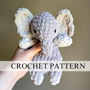 Könnte beinhalten: Ein gehäkeltes Elefanten-Plüschtier in Grau und Weiß mit großen Ohren und kleinen schwarzen Augen. Der Text "CROCHET PATTERN" ist im Bild zu sehen. Der Elefant ist aus weichem, strukturiertem Garn gefertigt.
