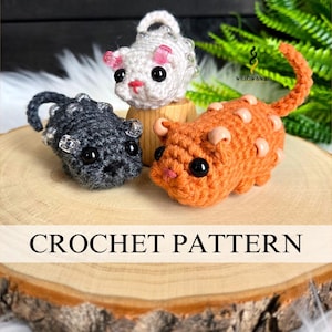 Puede incluir: Tres figuras de ratones de ganchillo en gris, blanco y naranja, con ojos negros y detalles de cuentas. El ratón naranja tiene una cola larga. Las figuras se exhiben sobre una rodaja de madera. El texto "CROCHET PATTERN" está en la parte inferior.