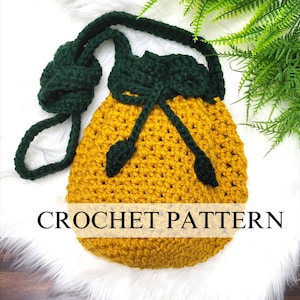 May include: A crocheted drawstring bag with a yellow body and green trim. The bag has a long green strap and is perfect for carrying small items.