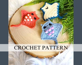 May include: Three handmade crochet stingrays in coral, blue, and cream colors. The coral ray has white accents, the blue ray has pink accents, and the cream ray has blue accents. The text "CROCHET PATTERN" is displayed on the image.