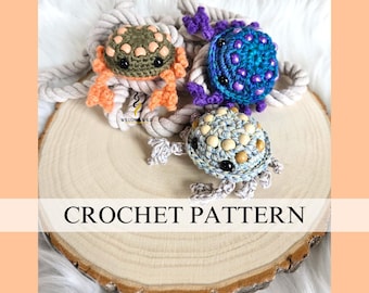 Könnte beinhalten: Drei gehäkelte Schildkrötenspielzeuge auf einer Holzoberfläche. Die Schildkröten sind grün, blau und beige mit verschiedenen farbigen Akzenten. Der Text "CROCHET PATTERN" ist unten im Bild sichtbar.
